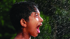 little boy exclaims as rain falls on his face
