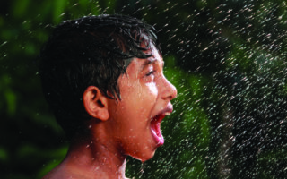 little boy exclaims as rain falls on his face
