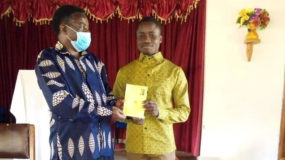 black man very happy after receiving his baptism certificate